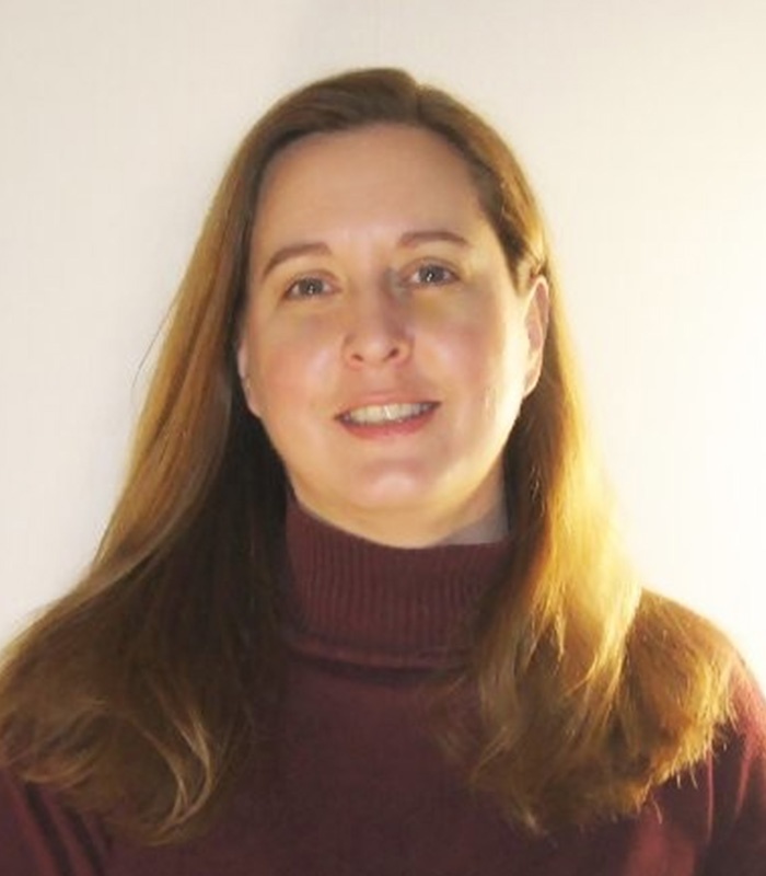 Meet Our Team - Professional and Welcoming Group at a Conference Table Faces the Camera, Team Leader Sitting on the Table with Arms Folded